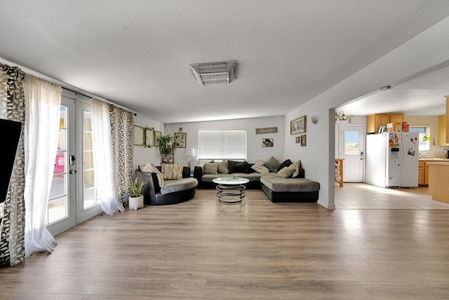 living area featuring light wood-type flooring and french doors