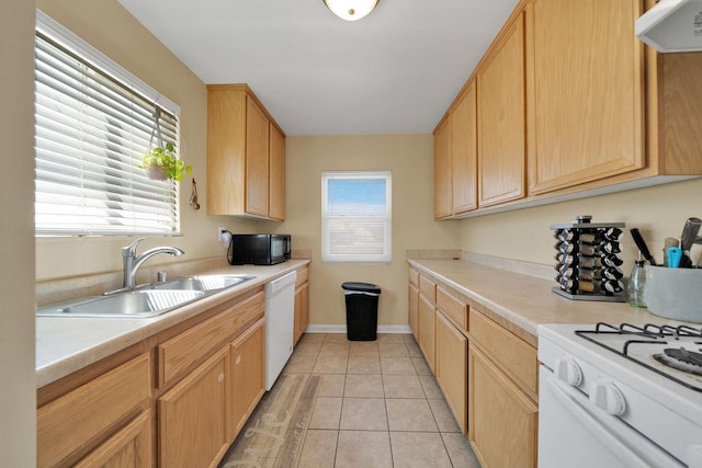 kitchen with light countertops, white appliances, a sink, and a healthy amount of sunlight