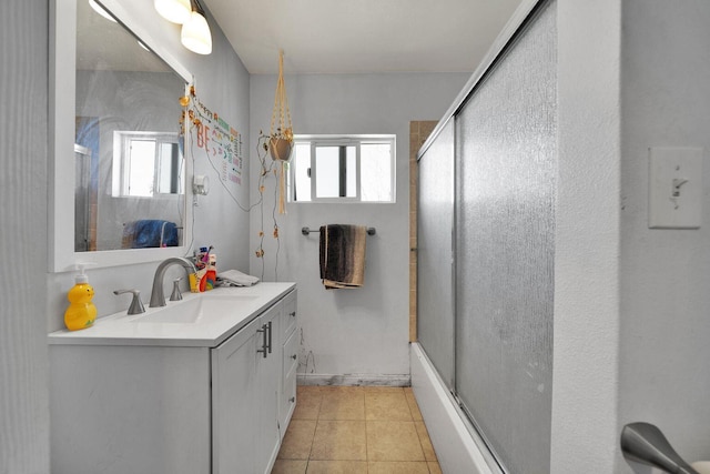 bathroom featuring combined bath / shower with glass door, vanity, and tile patterned floors