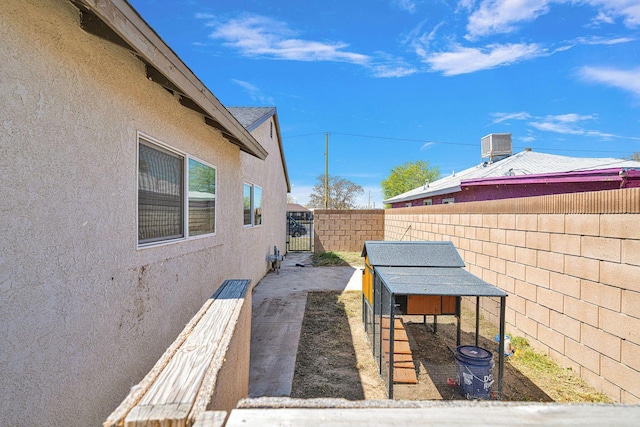 view of patio / terrace featuring an outbuilding, cooling unit, a fenced backyard, and exterior structure