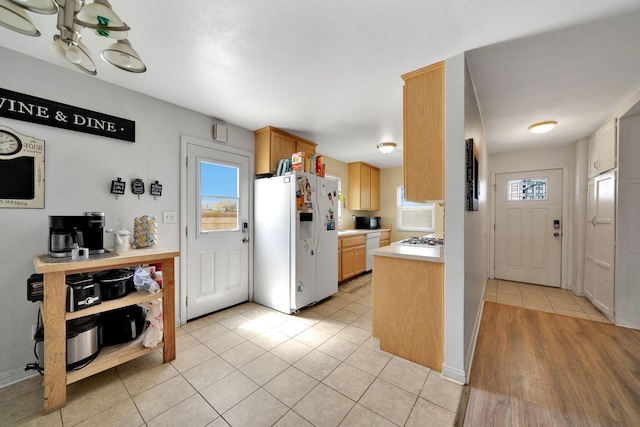 kitchen with white appliances, baseboards, light countertops, and light tile patterned flooring