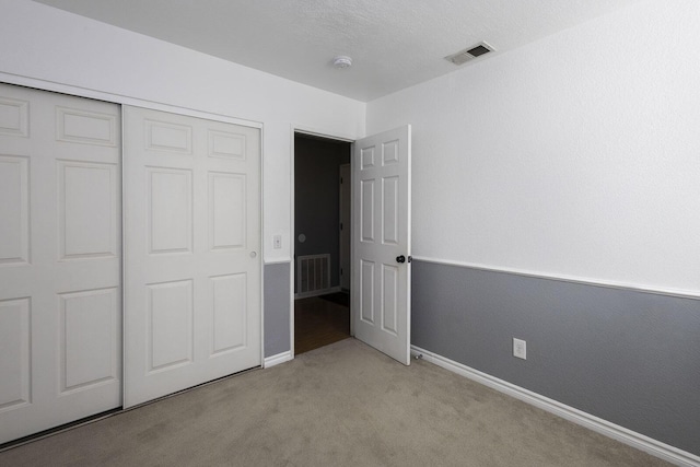 unfurnished bedroom featuring baseboards, visible vents, and light colored carpet