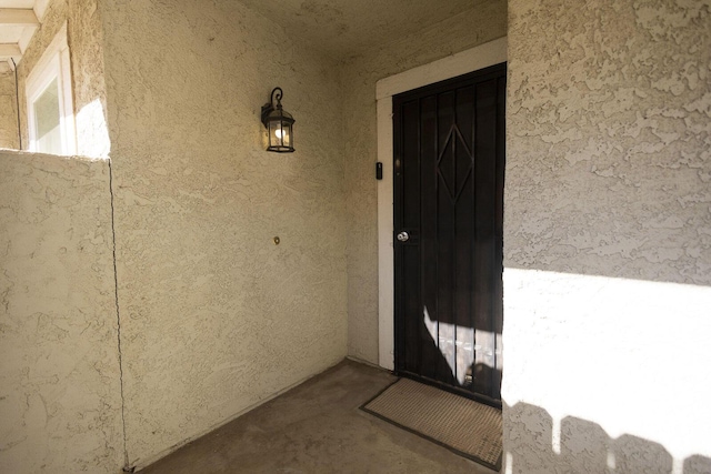 doorway to property featuring stucco siding