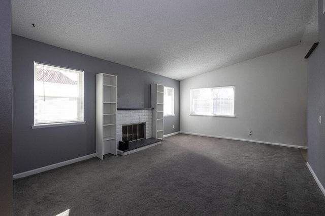 unfurnished living room with a fireplace, lofted ceiling, dark carpet, a textured ceiling, and baseboards