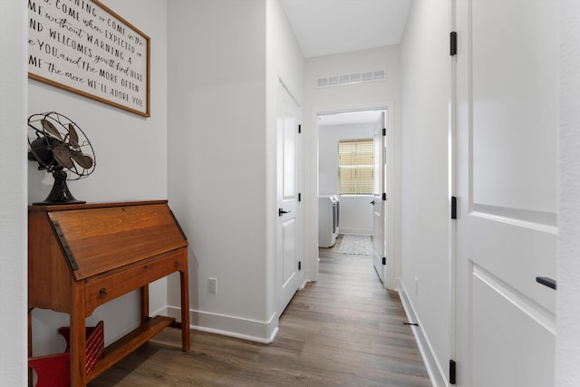 corridor with wood finished floors and baseboards