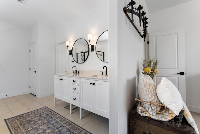 bathroom with double vanity, tile patterned flooring, and baseboards