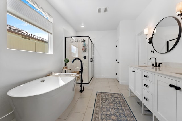 bathroom featuring a stall shower, vanity, a freestanding bath, tile patterned flooring, and baseboards