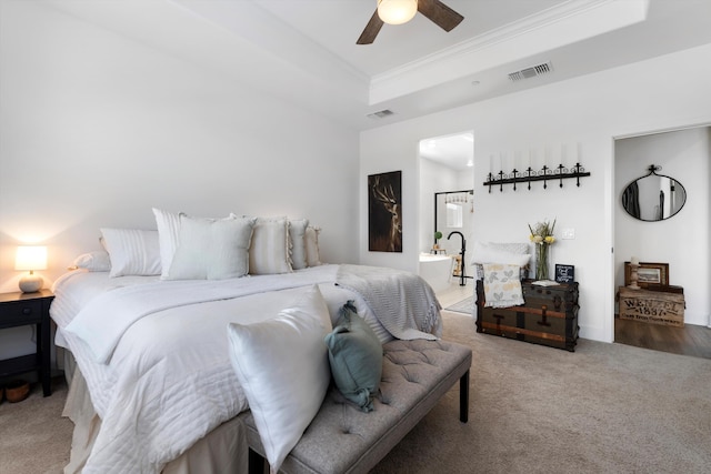 bedroom featuring a raised ceiling, carpet floors, crown molding, and a ceiling fan