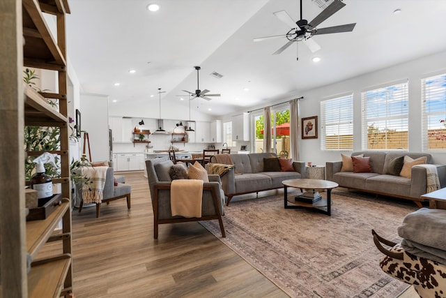 living room featuring ceiling fan, lofted ceiling, wood finished floors, and recessed lighting