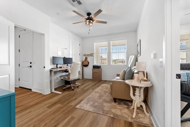 home office featuring wood finished floors, a ceiling fan, and baseboards