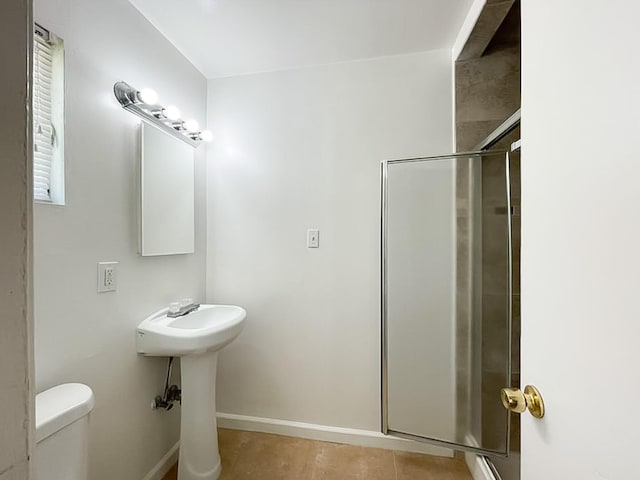 45567 Andale Ave, Lancaster, CA 93535 - bathroom featuring a shower stall, toilet, baseboards, and a sink