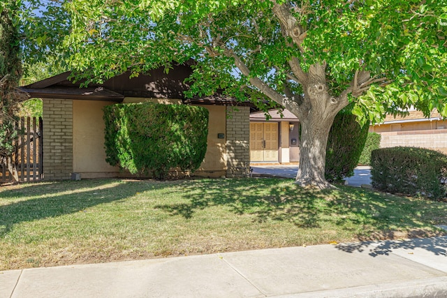 obstructed view of property with a garage and a front lawn