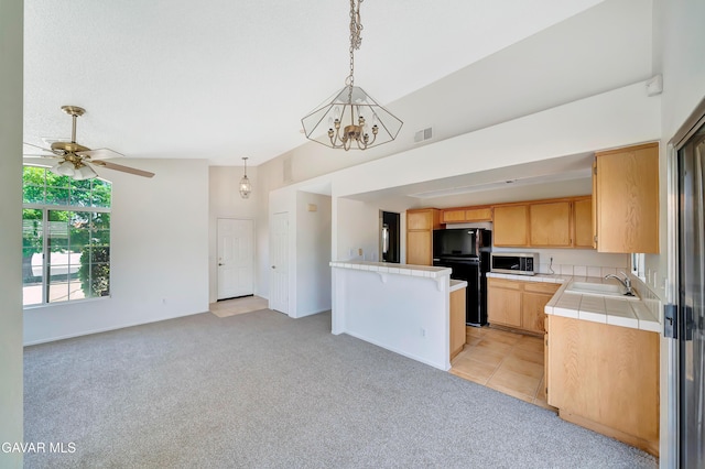 3524 San Jacinto Ave, Rosamond, CA 93560 - kitchen with freestanding refrigerator, stainless steel microwave, tile countertops, light brown cabinets, and open floor plan