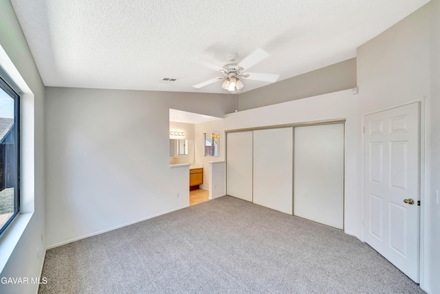 3524 San Jacinto Ave, Rosamond, CA 93560 - unfurnished bedroom featuring light colored carpet, a closet, a textured ceiling, ceiling fan, and ensuite bathroom
