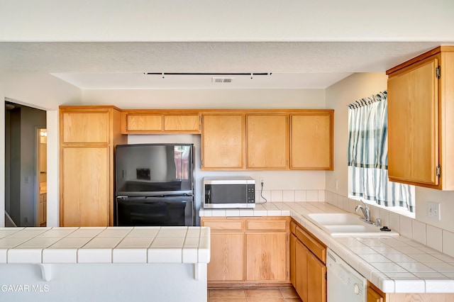 3524 San Jacinto Ave, Rosamond, CA 93560 - kitchen featuring stainless steel microwave, freestanding refrigerator, dishwasher, tile counters, and light tile patterned floors