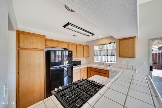 3524 San Jacinto Ave, Rosamond, CA 93560 - kitchen with refrigerator, tile counters, gas stovetop, light brown cabinetry, and white dishwasher