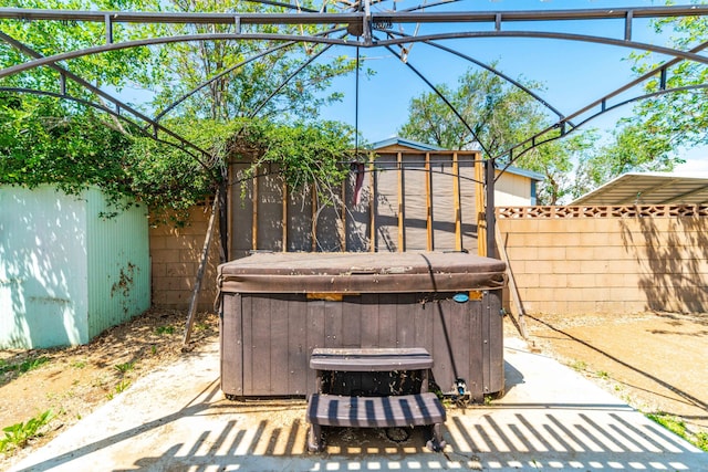 view of patio / terrace featuring a hot tub and a fenced backyard