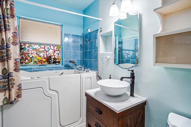 full bath featuring vanity, toilet, and a tub to relax in
