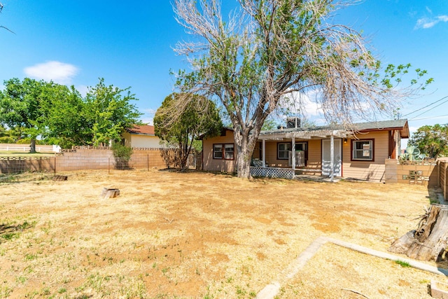 back of property featuring a fenced backyard and a porch