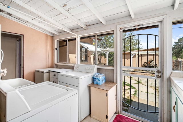 clothes washing area with cabinet space, washing machine and dryer, plenty of natural light, and wood ceiling