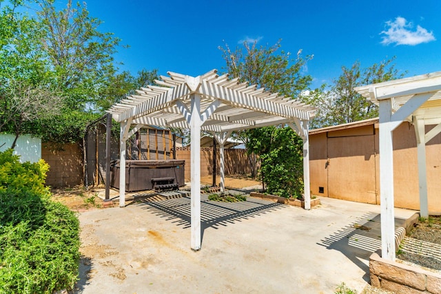 view of patio / terrace with a hot tub, a pergola, and a fenced backyard
