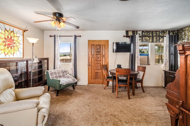 carpeted dining space featuring a ceiling fan and baseboards