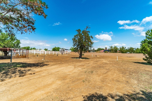 view of yard with fence and a rural view