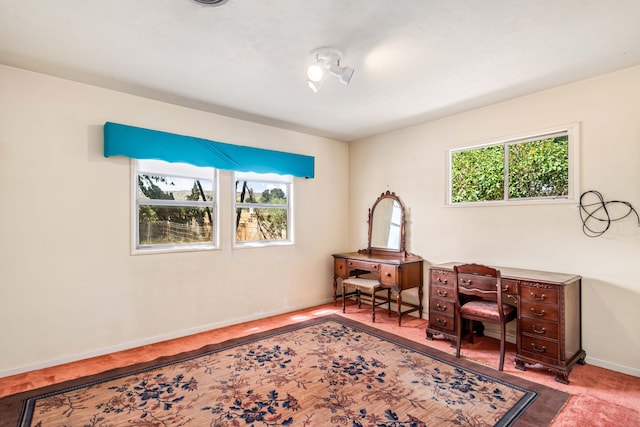 living area with plenty of natural light, baseboards, and carpet floors