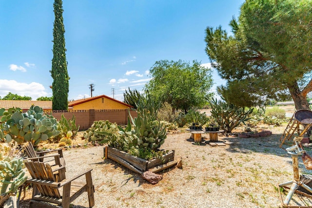 view of yard featuring fence and a vegetable garden