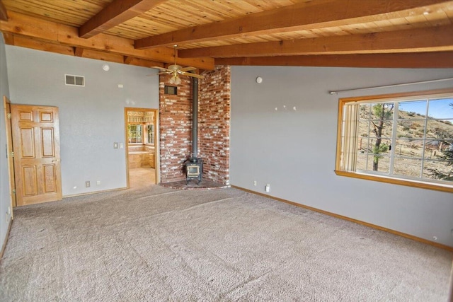 unfurnished living room featuring visible vents, wood ceiling, a wood stove, vaulted ceiling with beams, and carpet floors