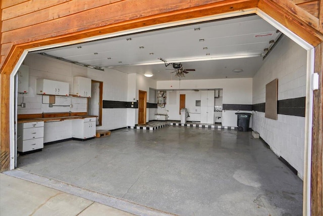 garage with concrete block wall and a garage door opener