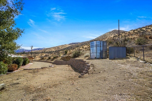 view of yard featuring a mountain view and fence