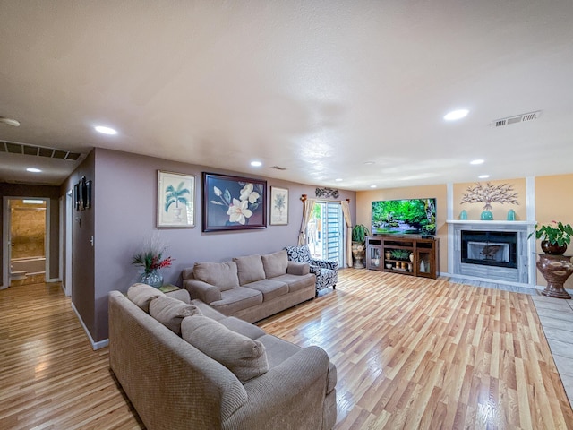 45431 Sancroft Ave, Lancaster, CA 93535 - living room with light wood finished floors, baseboards, a glass covered fireplace, and recessed lighting