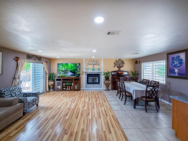 45431 Sancroft Ave, Lancaster, CA 93535 - living area with baseboards, plenty of natural light, a glass covered fireplace, a textured ceiling, and recessed lighting