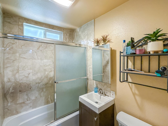 45431 Sancroft Ave, Lancaster, CA 93535 - full bathroom with toilet, combined bath / shower with glass door, a textured wall, and vanity