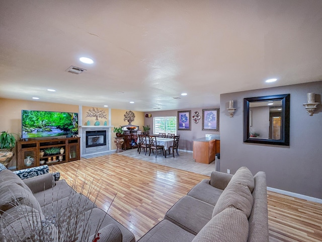 45431 Sancroft Ave, Lancaster, CA 93535 - living room featuring recessed lighting, a glass covered fireplace, baseboards, and light wood-type flooring