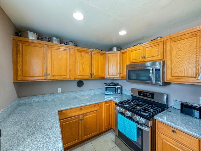 45431 Sancroft Ave, Lancaster, CA 93535 - kitchen with appliances with stainless steel finishes, recessed lighting, and brown cabinetry
