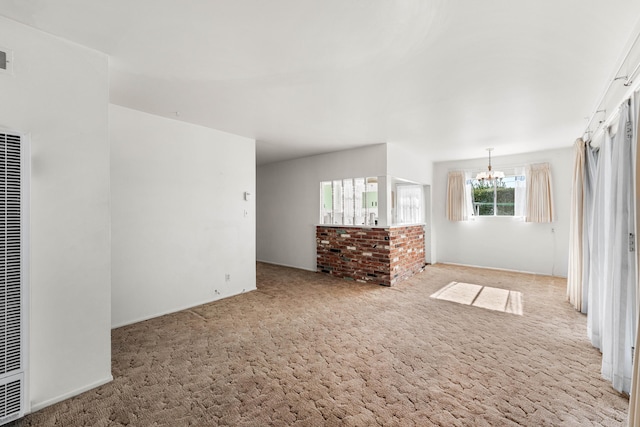 unfurnished living room with a chandelier and light carpet