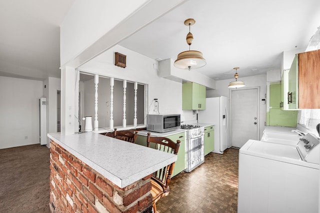 kitchen with white appliances, a kitchen breakfast bar, kitchen peninsula, washer and clothes dryer, and a healthy amount of sunlight