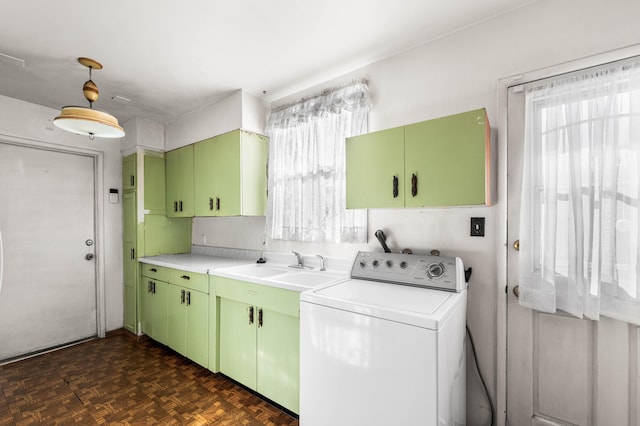 washroom with dark parquet flooring, washer / clothes dryer, cabinets, and sink