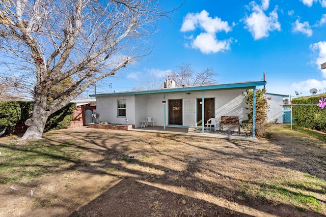 back of house with a yard and a patio