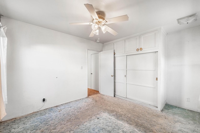 unfurnished bedroom with light carpet, a closet, and ceiling fan