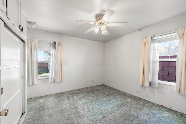 carpeted spare room featuring ceiling fan