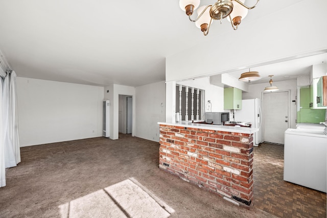 kitchen with white refrigerator, a chandelier, washer / dryer, and kitchen peninsula