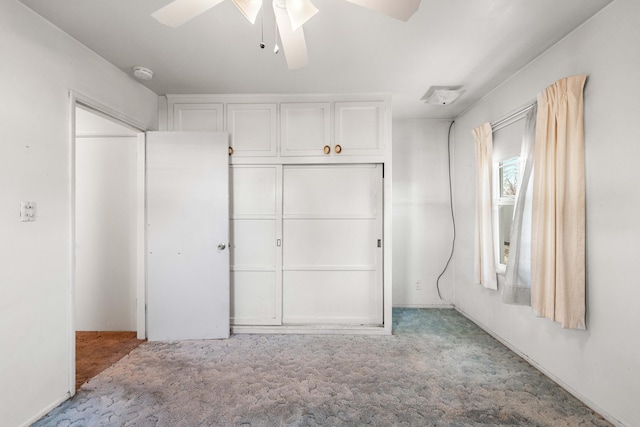 unfurnished bedroom featuring light colored carpet, ceiling fan, and a closet