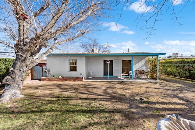 back of property featuring a patio area and a yard