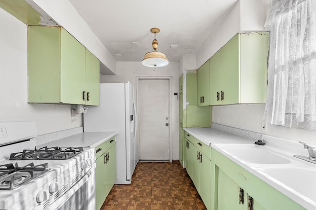 kitchen with white appliances, dark parquet flooring, sink, and green cabinets