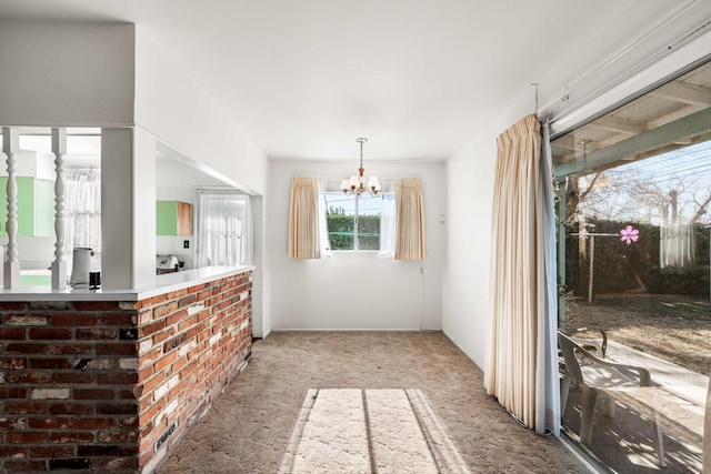 carpeted dining room featuring an inviting chandelier