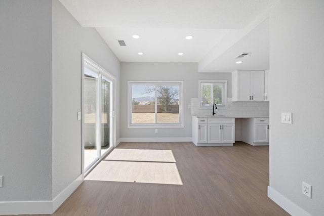 4046 Kona Ct, Palmdale, CA 93552 - kitchen featuring white cabinetry, wood finished floors, light countertops, tasteful backsplash, and recessed lighting
