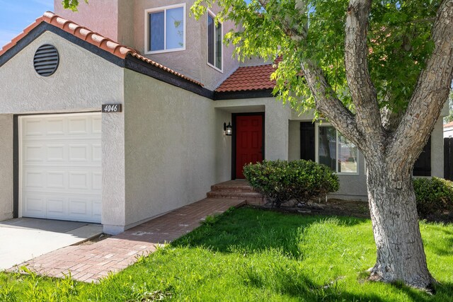 4046 Kona Ct, Palmdale, CA 93552 - view of front of house featuring stucco siding, a tile roof, a front yard, and a garage